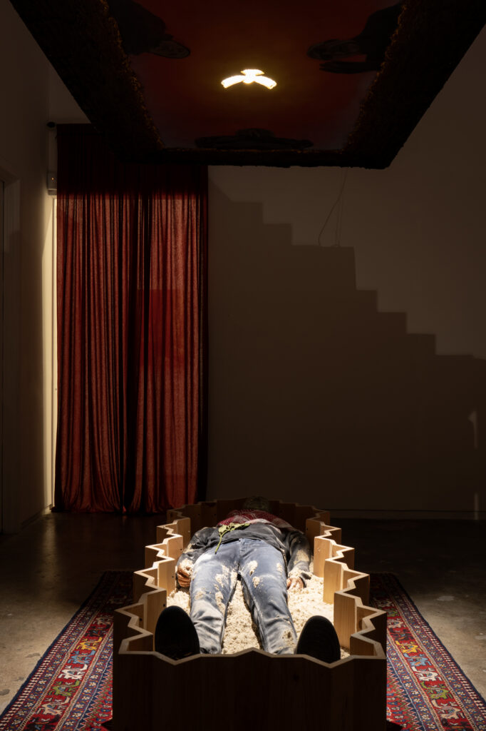 **detail** **installation** Funerary Room , 2024, Installation- Wooden Coffin, Painting on Wood, Sarcophagus in Plaster, Sand, Rug, Keffiyeh, Jeans,