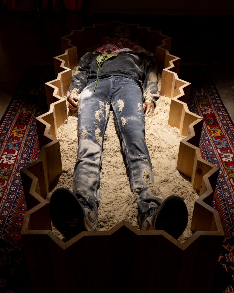 **detail** **installation** Funerary Room , 2024, Installation- Wooden Coffin, Painting on Wood, Sarcophagus in Plaster, Sand, Rug, Keffiyeh, Jeans,