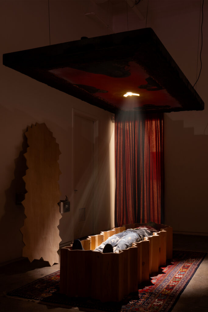 **installation** Funerary Room , 2024, Installation- Wooden Coffin, Painting on Wood, Sarcophagus in Plaster, Sand, Rug, Keffiyeh, Jeans, Bronx Kia Hoodie, Nike Air Jordans, Plaster Gold Plated Figure.